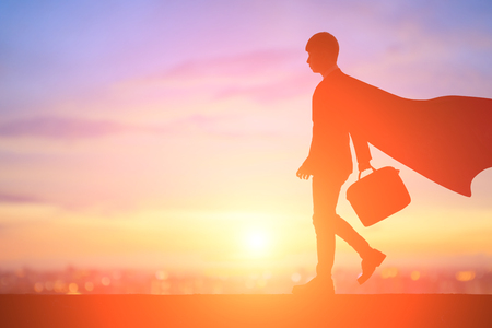 silhouette of super businessman with cape walk in the sunsetの写真素材