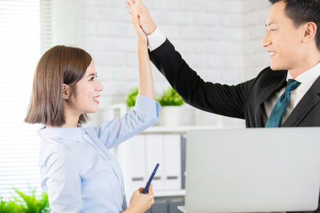 Asian business colleague meeting and give five at the office