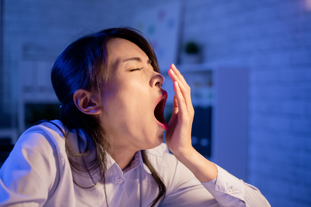 Asian woman overtime work and feel sleepy in the officeの写真素材