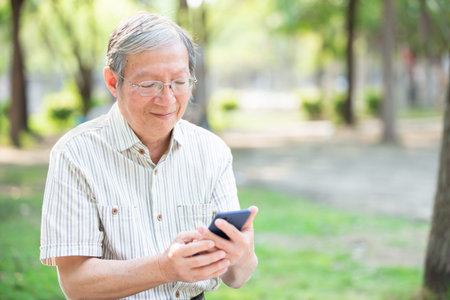 Older man use cellphone in the park