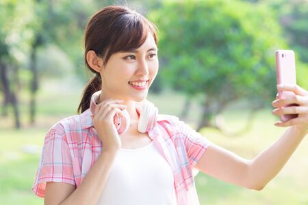 young asian girl take selfie with her smart phoneの写真素材