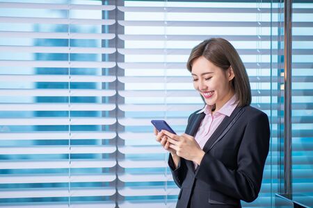 Young asian business woman use smart phone in the officeの写真素材