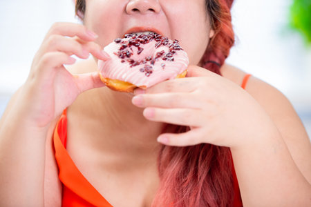 asian plus size woman eat a donut happily