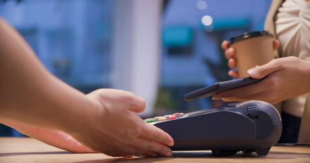mobile payment concept - close up of Young woman pays by contactless phone to credit card system for...