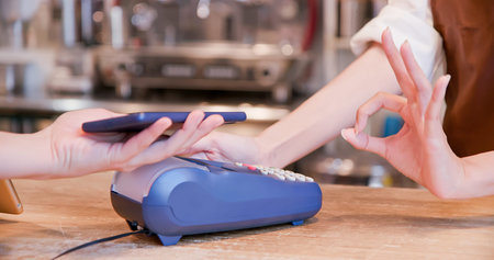 mobile payment concept - In the Cafe close up of Woman Makes Coffee For a Customer Who Pays by Phone...