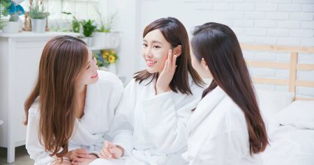 Smiling asian women apply cream on her face and feel goodの写真素材