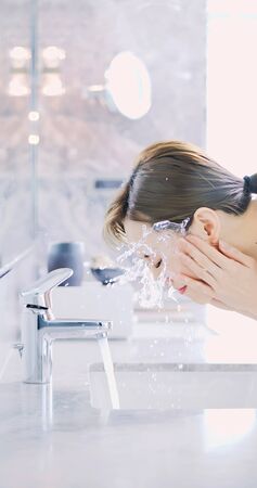 Vertical of beauty asian woman wash her face in the morningの写真素材
