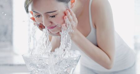 Young asian woman wash her face in the morningの写真素材