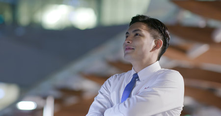 Young businessman look somewhere outdoor in the eveningの写真素材