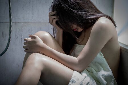 Young scared asian woman in domestic and  violence and sit near the cornerの写真素材