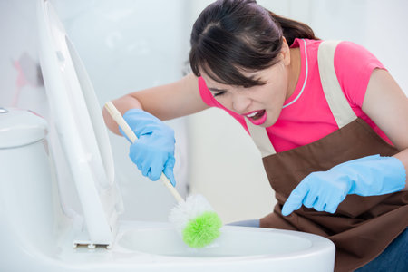 asian woman brush the toilet and it is dirtyの写真素材
