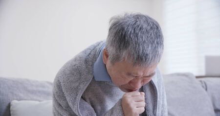 old asian man get a cold and cough at homeの写真素材