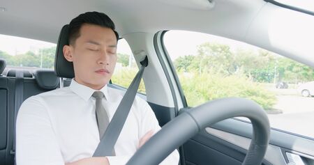 business asian man sleep in an autonomous self driving carの写真素材