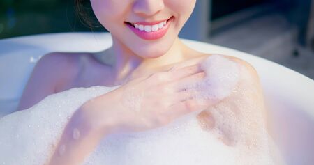 asian woman taking a bubble bath in the eveningの写真素材