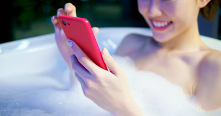 woman use smart phone happily while bathing at night