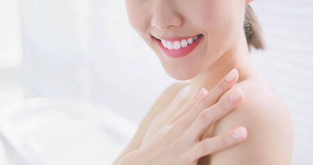 young beauty woman touch her skin and enjoy herself in the bathroomの写真素材