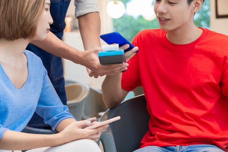 mobile payment concept - close up of man Pays bills by Phone to Credit Card System