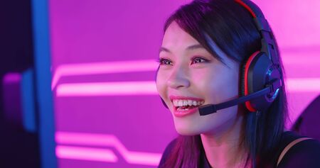 Young Asian Pretty Pro Gamer having live stream and playing in Online Video Gameの写真素材
