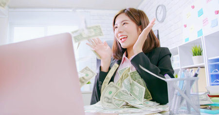 internet online business making money concept - asian business woman excited with banknote from...