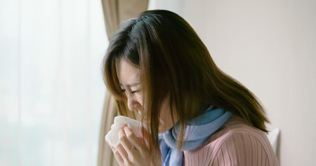 asian woman sick and sneeze with tissue paper in the bedroom