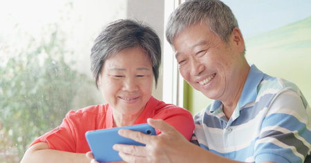elder couple use smartphone and share something on it