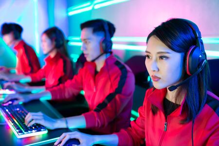 Team of asian teenage cyber sport gamers play in multiplayer PC video game on eSport tournamentの写真素材
