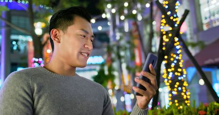 asian man use smart phone outdoor in the eveningの写真素材