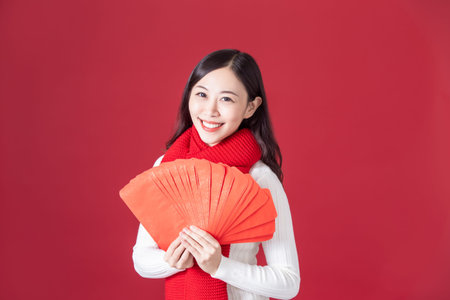 asian woman hold red envelopes and smile to youの写真素材
