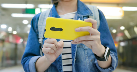 asian young woman use 5g smartphone on the subway stationの写真素材