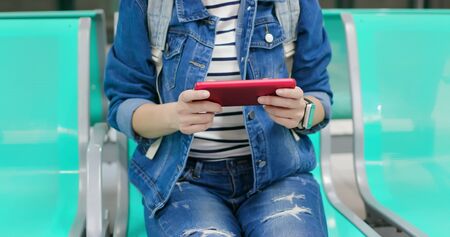 close up of asian young woman play game with 5g smartphone on the metro stationの写真素材