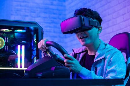 asian gamer play car racing game with wearing vr glasses の写真素材