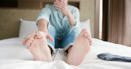 man scratch the itch by hand with athlete foot problem in the room