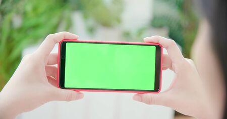 woman use smart phone with green screen at homeの写真素材