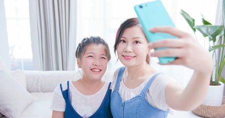 Mom and daughter take selfie together happily