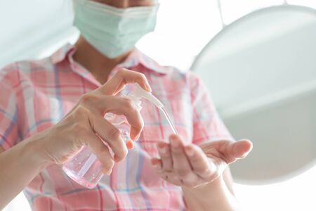 woman use sanitizer gel and wash hands by alcohol or soap in order to kill virus prevent the spread of bacteria with surgical face maskの写真素材