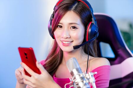 cybersport gamer have live stream and playing mobile game on the smartphone at homeの写真素材