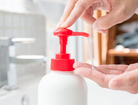 close up of woman hands pushing pump plastic soap bottle to prevent the spread infectious disease...