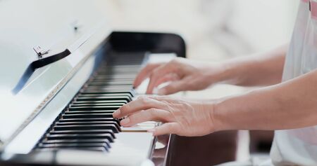 close up of asian old man practice playing the piano at homeの写真素材