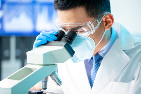 close up of asian microbiologist biotechnology researcher or medical worker look microscope in the...