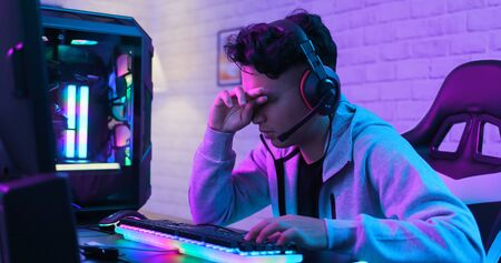Young asian esport gamer feel painful while playing in Online Video Game because his eye is tiredの写真素材
