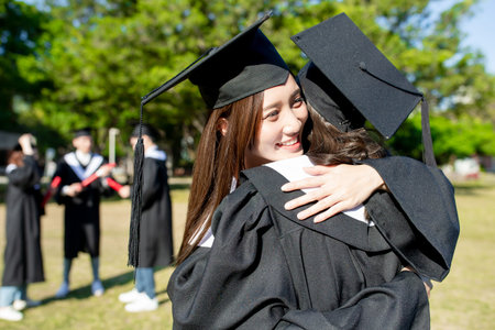 happy female graduate student give hug to her best friendの写真素材