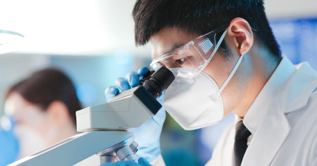 asian microbiologist biotechnology researcher or medical worker look result of blood test with...