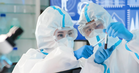 asian microbiologist biotechnology researcher or medical worker look microscope in the lab