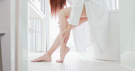 Asian beauty massage leg gently in bathroomの写真素材