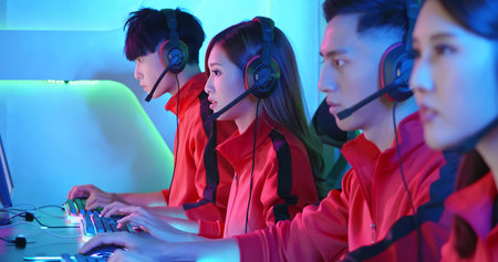 Team of asian teenage cyber sport gamers play in multiplayer PC video game on eSport tournament