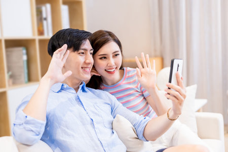 asian couple looking some information on the internet together by digital tablet at home happilyの写真素材