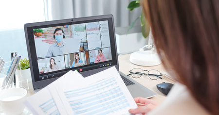 telework concept-rear view of asian man use computer and headset to join a video meeting at home