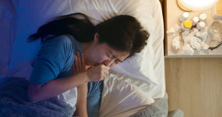 Top view of asian woman sick and has sore throat in the bedroomの写真素材