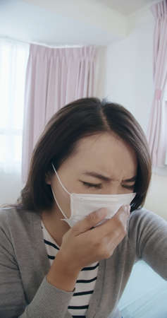 Telemedicine concept-asian female patient consult her health condition to doctor by talking on mobile phone and she has feverの写真素材