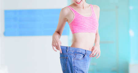 weight loss concept of asian woman in her old big jeansの写真素材